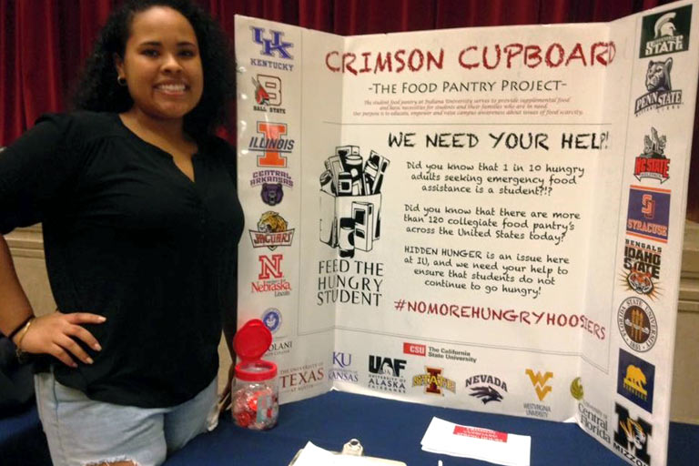 a woman with a trifold that has information about crimson cupboard