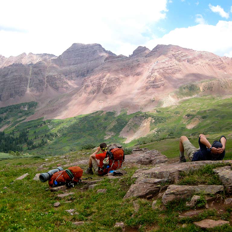 two hikers looking up at a mountain
