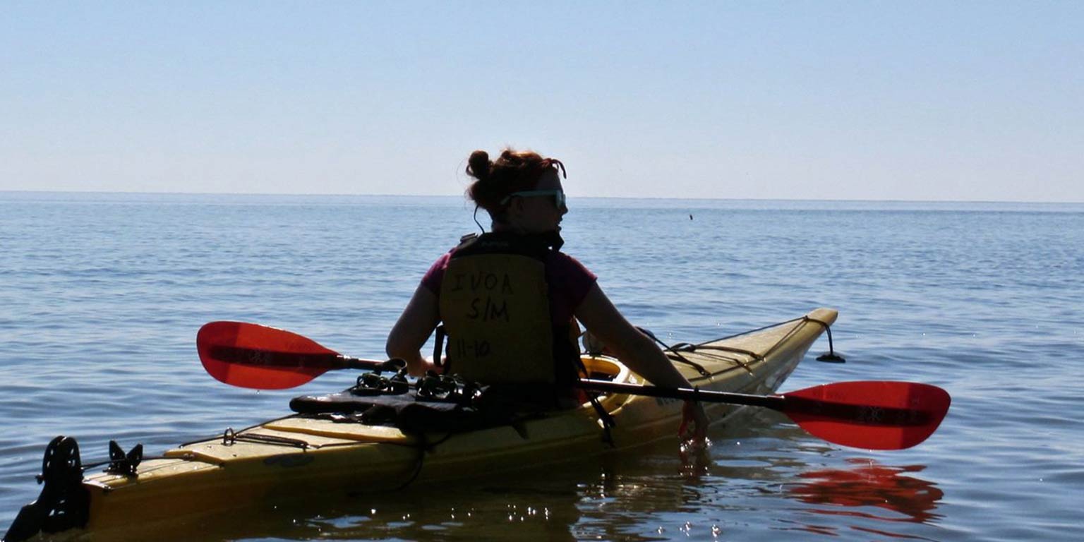 young woman in a kayak, floating on still water