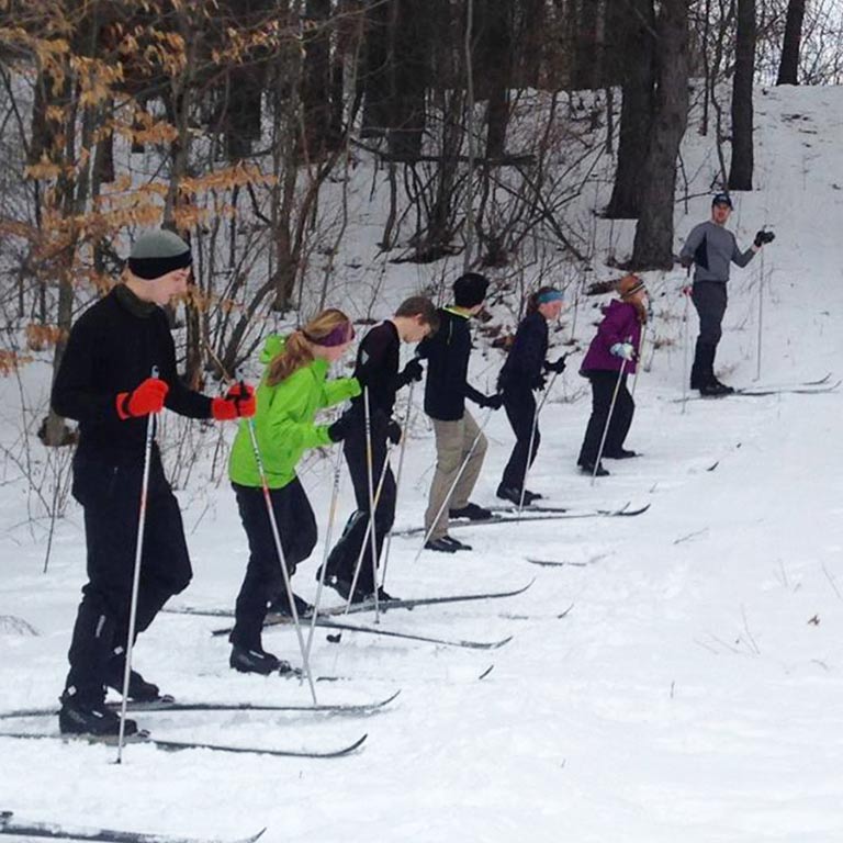 several young people and an instructor wearing cross country skis