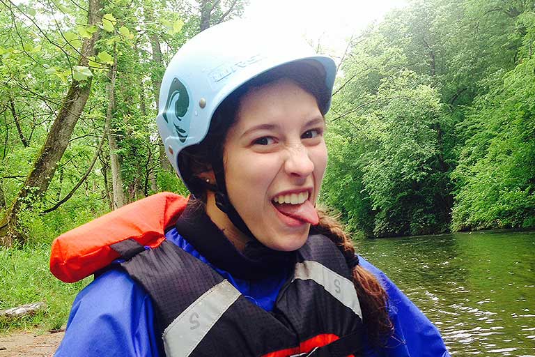 a kayaker sticks her tongue out to the side